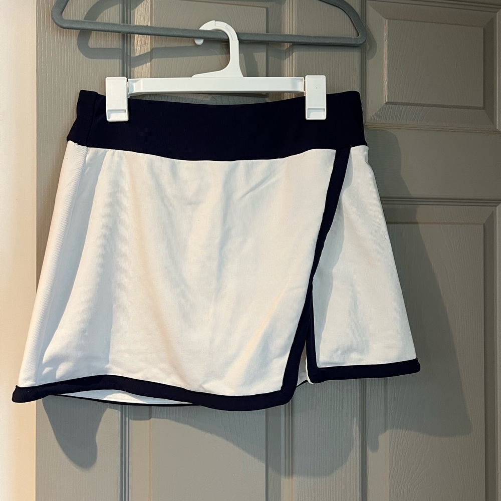 White and navy blue golf skort. Built in shirts. Slit in front. Size L.